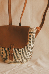 Hand-woven palm backpack.